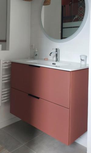 La salle de bains est pourvue d'un lavabo rouge et d'un miroir. dans l'établissement Le Cosy Luberon - Gite provençal avec piscine, à Viens