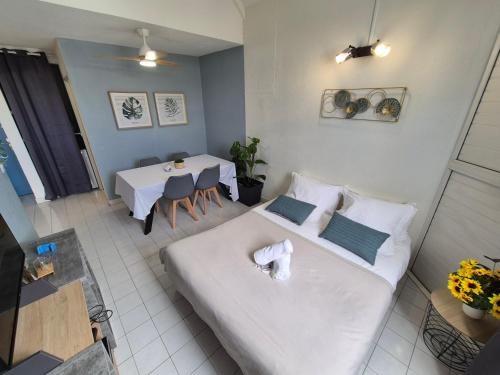 a room with a bed and a table with chairs at Coeur Citadin - 4 personnes - Plein Centre Ville 2eme étage in Saint-Denis