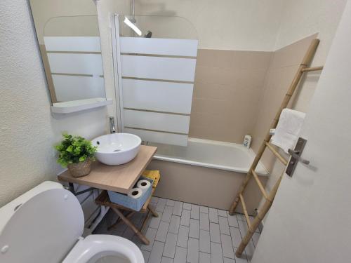 a bathroom with a sink and a toilet and a bath tub at Coeur Citadin - 4 personnes - Plein Centre Ville 2eme étage in Saint-Denis