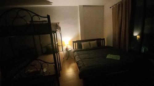 a dark room with a bed and a lamp at Amaretto Hostel in Surat Thani