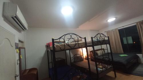 a bedroom with two bunk beds in a room at Amaretto Hostel in Surat Thani