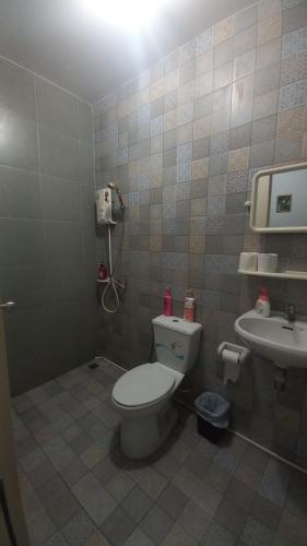 a bathroom with a toilet and a sink at Amaretto Hostel in Surat Thani