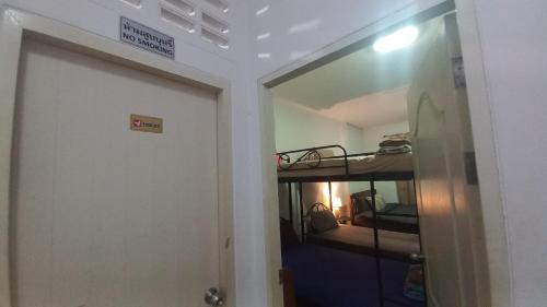 a door leading to a room with a bunk bed at Amaretto Hostel in Surat Thani