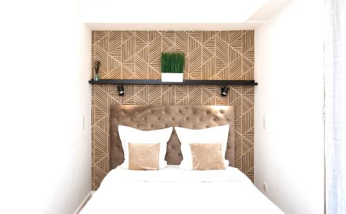 - une chambre avec un lit blanc et une tête de lit marron dans l'établissement Bel appartement Port de Nice avec terrasse, parking, à Nice