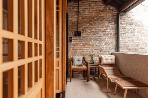 a hallway with benches and a table and a brick wall at the Wild Luxury Holiday Inn in Xingping