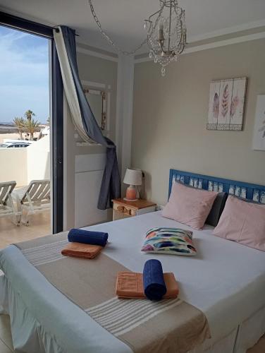a bedroom with a large bed with towels on it at Casa Maria Cotillo Mar in El Cotillo