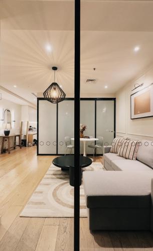 a living room with a couch and a table at Collins Escape - 2 bedrooms with Collins St Balcony in Melbourne
