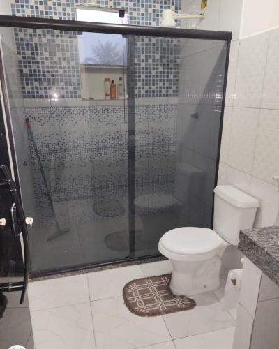a bathroom with a shower with a toilet and a glass shower at Bangalô MAR & SOL in Saquarema