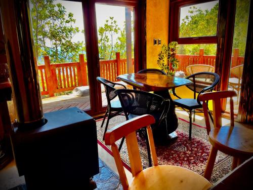 a room with tables and chairs and a table and windows at Cozzy Cabin at "Explore-Cafe & Lodge" Located in Duhatao, Chiloe Island, Patagonia, Chile in Ancud