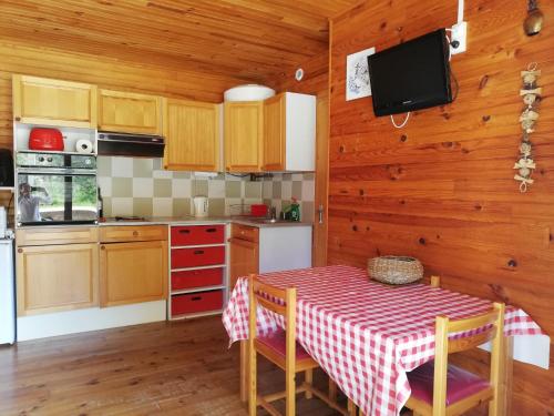 une cuisine avec une table et un chiffon de table rouge et blanc dans l'établissement La Cabane d'Oza, à Saint-Pierre-dels-Forcats