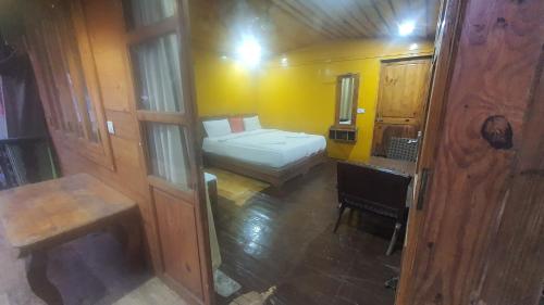 a small room with a bed and a desk at Grand palolem- cottages and cafe' in Canacona