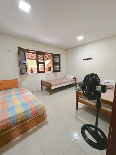 a room with two beds and a fan in it at Sítio Caju in Aquiraz