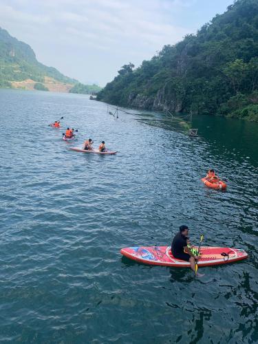 a group of people in kayaks on a river at Nắng Village in Hòa Bình