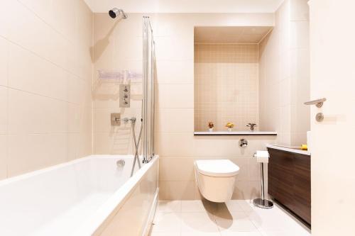 a bathroom with a tub and a toilet and a sink at Bright & Modern One Bedroom Flat in Farringdon in London