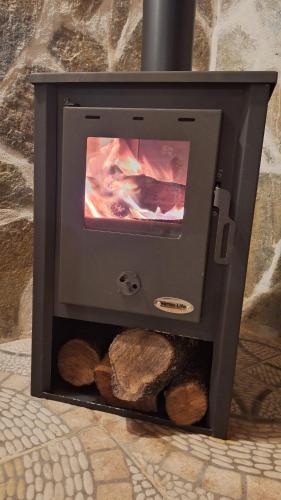 a wood stove with logs inside of it at El Zaguan in Sotillo de la Adrada