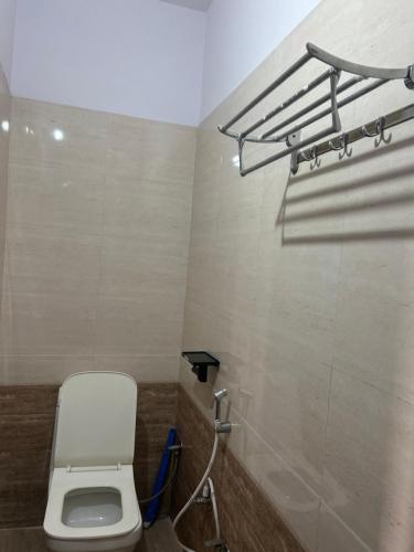 une salle de bain avec des toilettes blanches dans une chambre dans l'établissement Golden Peacock Heritage Home Stay, à Jaipur