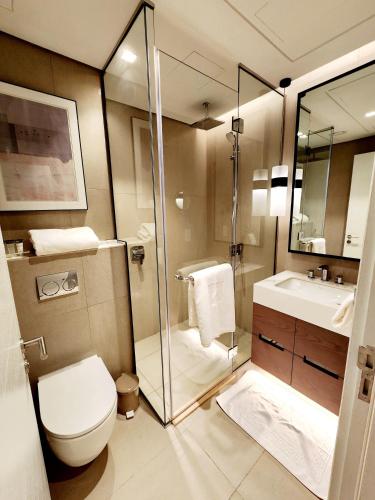 a bathroom with a toilet and a shower and a sink at Solo RealtyHH Apartments - Address Residence Fujairah in Sharm