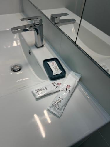 a bathroom sink with a cell phone and toothpaste at Casa vacanza Natasha in Como