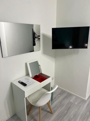 a white desk with a chair and a tv on a wall at Casa vacanza Natasha in Como