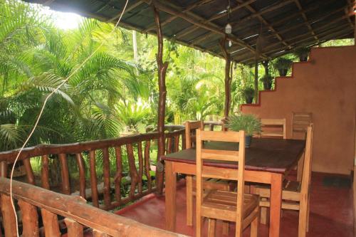 a wooden deck with a table and chairs on it at Sigiriya Nature View home Stay in Sigiriya