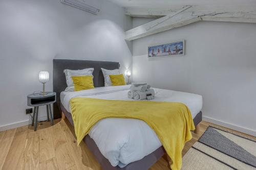 une chambre avec un grand lit avec une couverture jaune dans l'établissement Loft Croisette Standing Presta, à Cannes