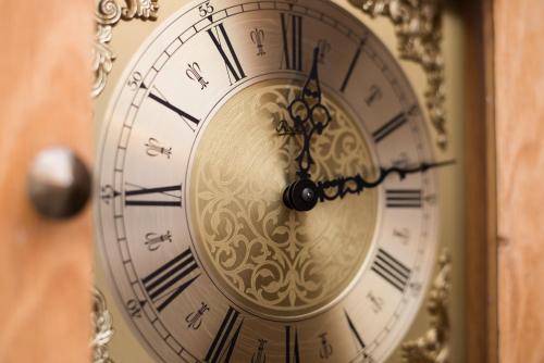 a gold clock with roman numerals on a wall at Beehive Hotel and CoWorking in Varna City