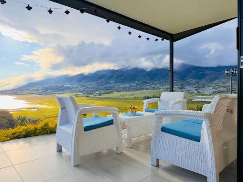a patio with chairs and a view of a mountain at Cabañas en el Lago Calima in Calima