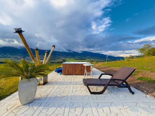 a bench sitting on a patio with a table at Cabañas en el Lago Calima in Calima