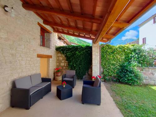 a patio with couches and chairs under a wooden roof at Cottege in Pietra sul Fiume in Frontone