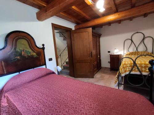a bedroom with a bed with a purple comforter at Cottege in Pietra sul Fiume in Frontone