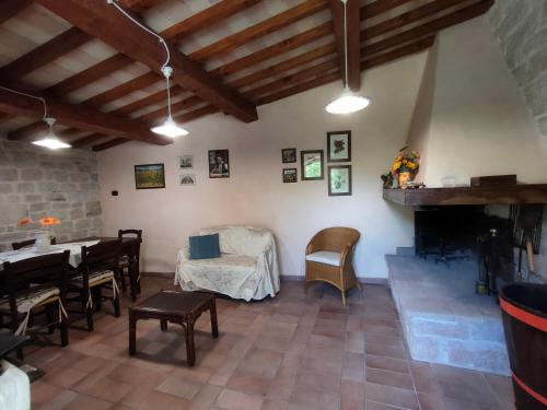 a living room with a table and a fireplace at Cottege in Pietra sul Fiume in Frontone