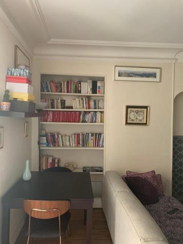 - un salon avec un canapé, une table et des livres dans l'établissement Parisien Solitaire, à Paris