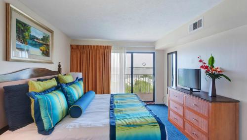 a bedroom with a bed with a television and a dresser at Bay Club of Sandestin, a VRI resort in Destin