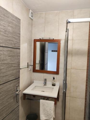 a bathroom with a sink and a mirror at L'Olivera Casa Rural in Castellbisbal