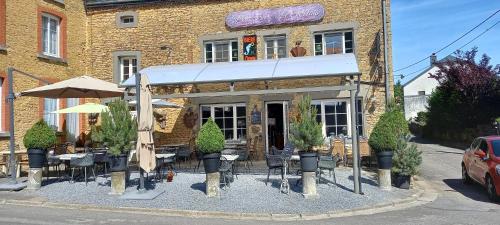 a restaurant with tables and chairs in front of a building at Le Relais de Chassepierre in Chassepierre