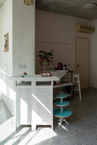 a kitchen with a counter and two blue stools at ResArt Traditional House in Nicosia