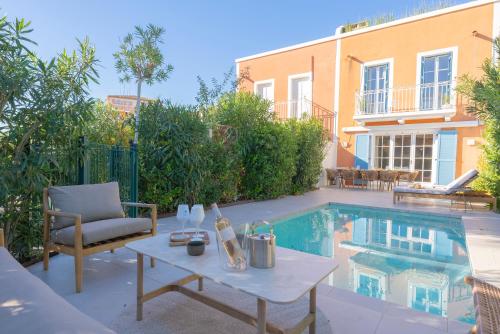 un patio avec une table à côté d'une piscine dans l'établissement Maison avec piscine et amarrage, à Grimaud