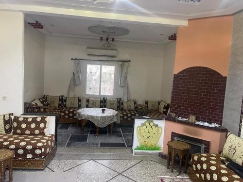 a living room with couches and a table and a fireplace at Achraf Immo in Fez