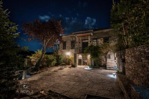 an old stone house with a courtyard at night at KATIKIA ZAGORI in Vitsa