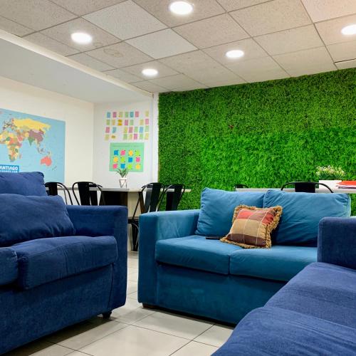 a room with two blue couches and a green wall at Habitación en Providencia - Metro Salvador in Santiago