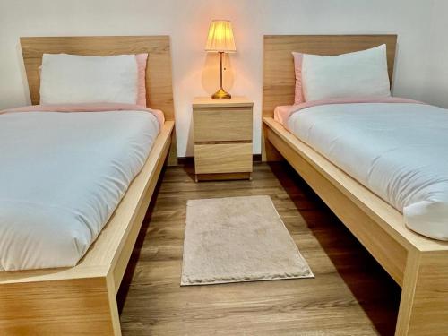 2 Einzelbetten in einem Zimmer mit einer Lampe in der Unterkunft M océan in Mohammedia
