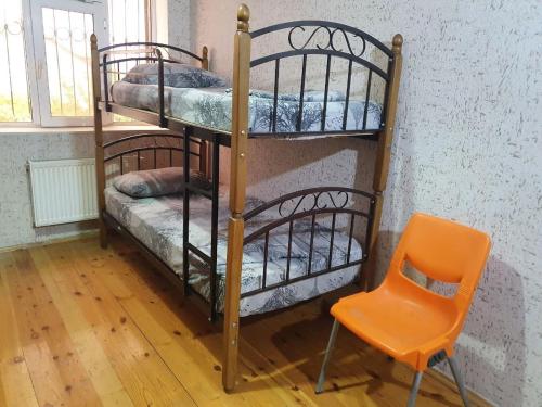 two bunk beds in a room with a orange chair at International Inn in Baku