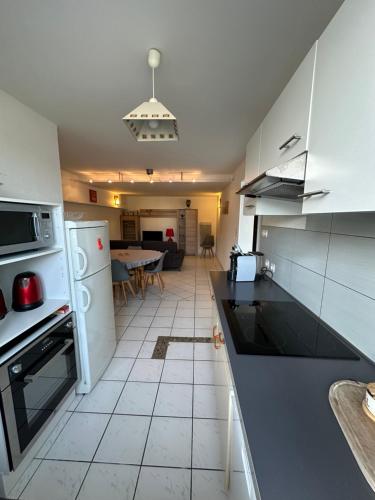 une cuisine avec des appareils électroménagers blancs et une salle à manger dans l'établissement Le Pouliguen/La Baule Appartement T3, au Pouliguen