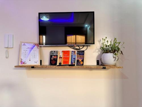a shelf with books and a mirror on a wall at Tamraght Surf Luxe A3 in Tamraght Ouzdar