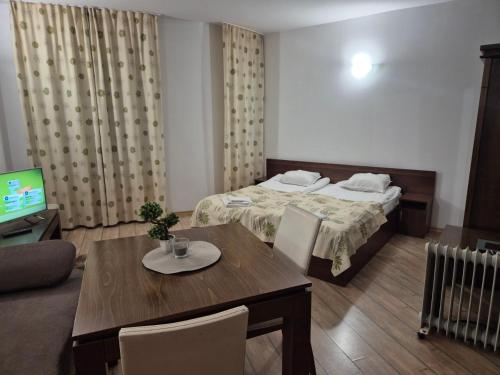 una stanza con un letto, un tavolo e una televisione di студио 307, к-с Стрийм Ризорт, Пампорово a Pamporovo