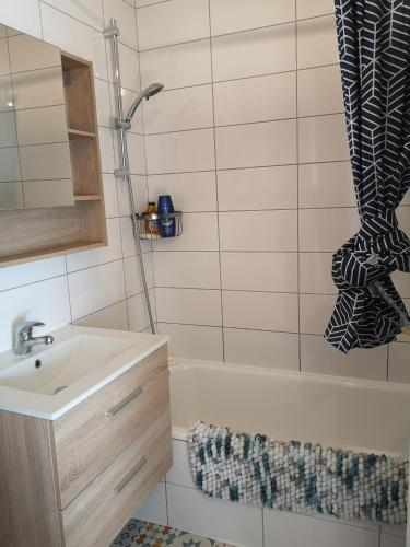 a bathroom with a sink and a tub and a shower at Superbe cocon de 44m2 in Longvic