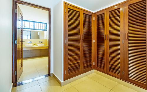 a bathroom with wooden closets and a bathroom with a sink at Luxury 3 bedroom beach front apartment in Mombasa