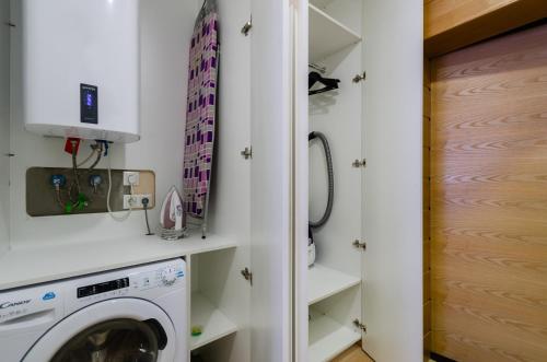 a laundry room with a washer and dryer at Petrovdom Apartments 78-170 in RC Nivki Park, 67А Beresteiskyi Avenue in Kyiv