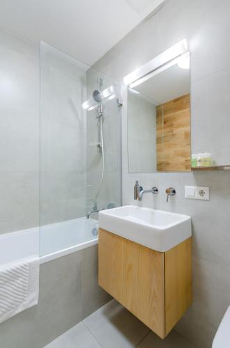 a bathroom with a sink and a tub and a mirror at Petrovdom Apartments 78-170 in RC Nivki Park, 67А Beresteiskyi Avenue in Kyiv