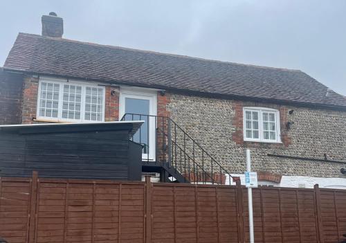 a brick house with a fence in front of it at The Studio, Arundel in Arundel